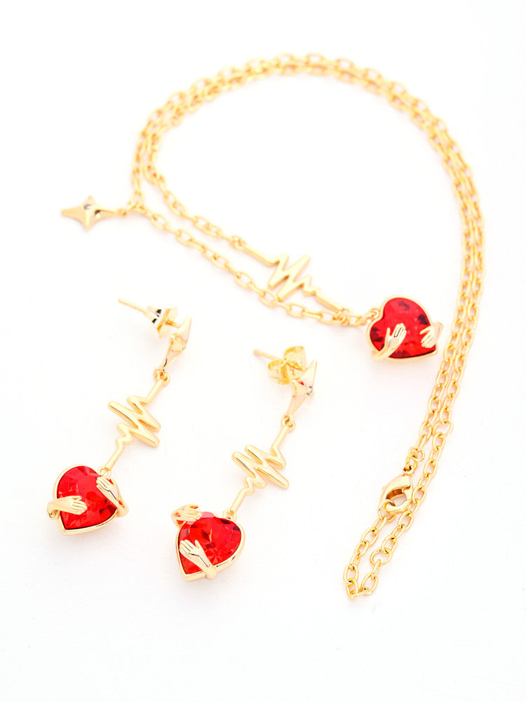 Gold Heartbeat Necklace and Earrings Set with Hugging Hands and Red Crystal Hearts