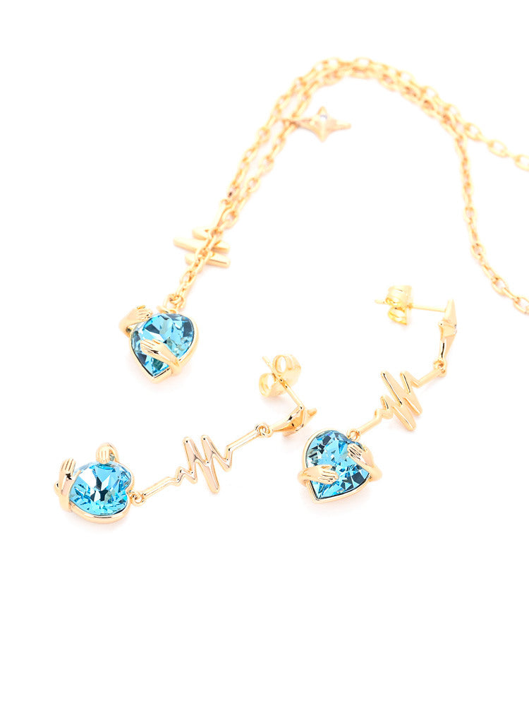 Gold Heartbeat Necklace and Earrings Set with Hugging Hands and Sky Blue Crystal Hearts